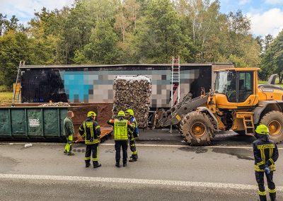 Mit einem Radlader werden die gelöschten Ballen auf einen Container verladen.
