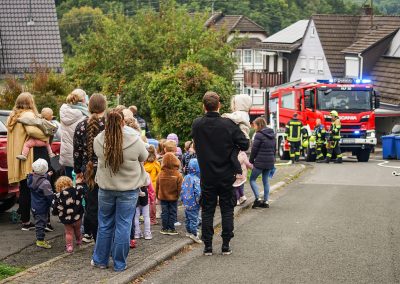 Erzieherinnen und Erzieher warten mit den Kindern in sicherer Entfernung vom Gebäude.