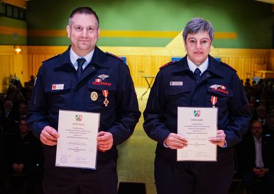 Ehrung für 35-jährige aktive Mitgliedschaft: Zwei Feuerwehrleute werden ausgezeichnet und zeigen ihre Urkunden.