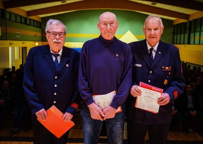 Ehrung für 60-jährige aktive Mitgliedschaft: Drei Feuerwehrleute werden ausgezeichnet und halten ihre Urkunden in den Händen.