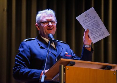 Während der Jahresdienstbesprechung blickt Feuerwehrleiter Christian Rogalski in seiner Rede auf das vergangene Jahr 2025 zurück und steht am Rednerpult, wobei er sein Redemanuskript hochhält.